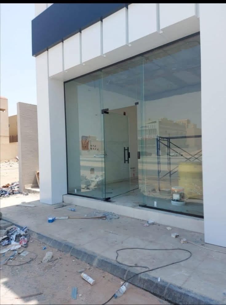 Shop front with ACP cladding above a full-height glass frontage
