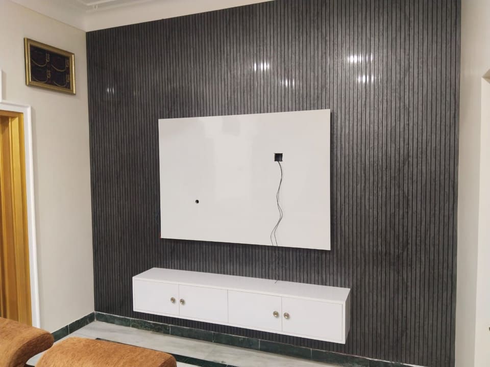 Fluted TV wall — Charcoal panelling, floating console